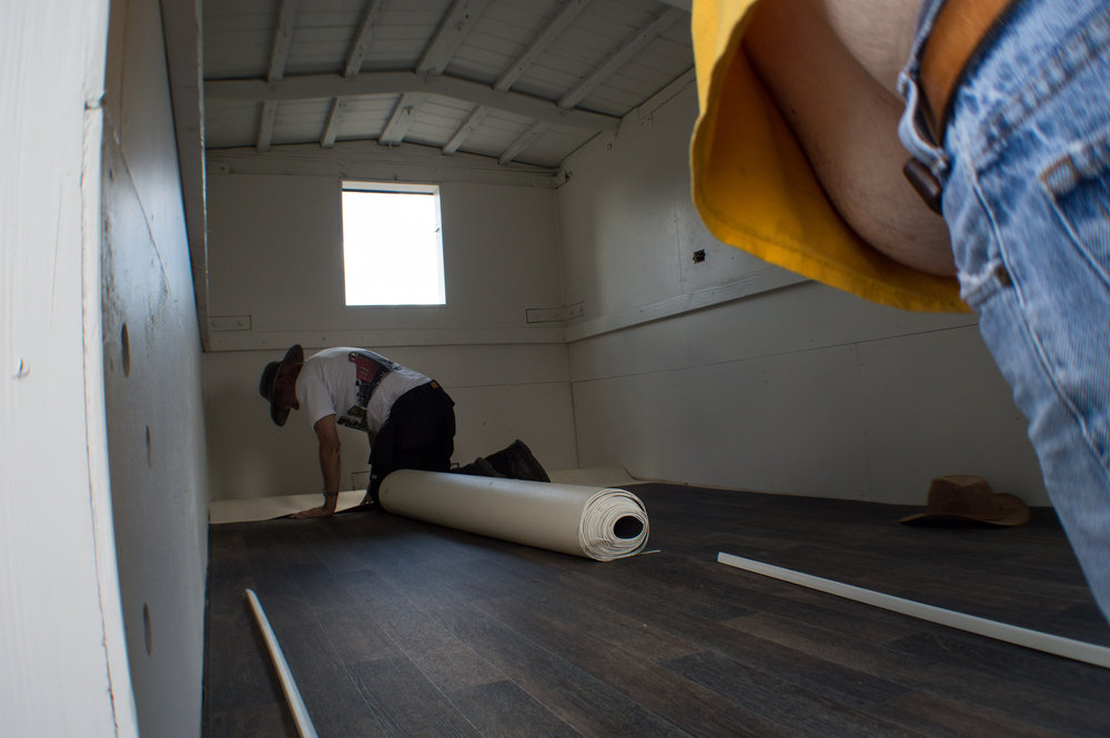 17 Here we see Mr. Beyer laying the new vinyl flooring in the kitchen storage car.jpg