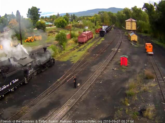9.7.16 The road engineer considers the ground a safe place to be as one hostler hoses down the cab and locomotive as the other loads coal.jpg