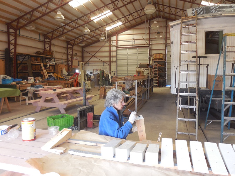 Noreen Breeding, team member of the 053 Cook Car restoration team, paints wood wedges.jpg