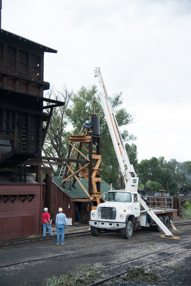 7-31-17 The tank is being lowered into place guided by the crew on the tower.jpg