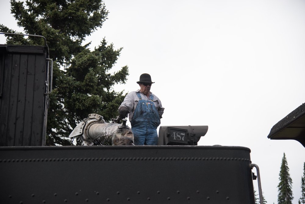 4 Engineer Jeff Stebbins in maning the water spout as 487 gets its tender filled.jpg