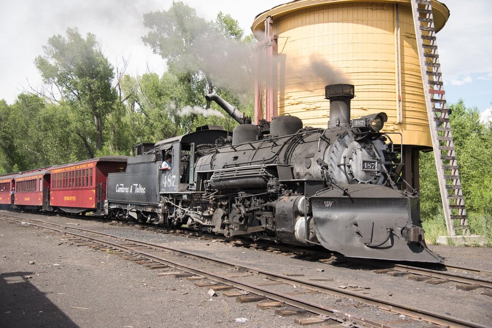 8 Train 215 comes by the water tank as it enters Chama yard.jpg