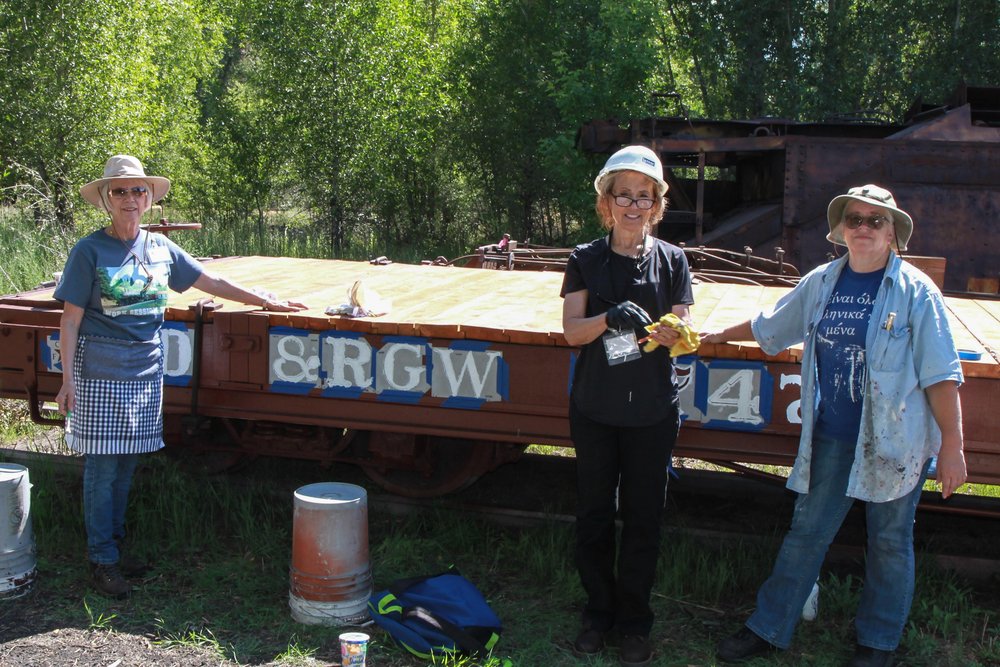 2018-07-23 The stencil crew is hard at work lettering this rebuilt flat car.jpg