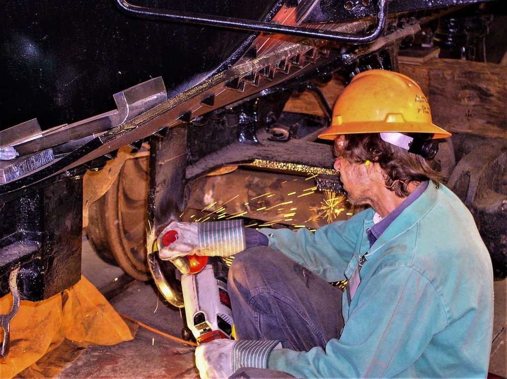 2018-07-27 Grinding of the truck frame under one of the tank cars being rehabed.jpg