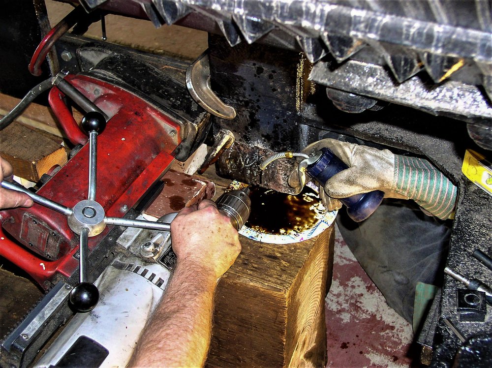 2018-07-27 Two people work in drilling into frame of the car, that is one heavy duty drill.jpg