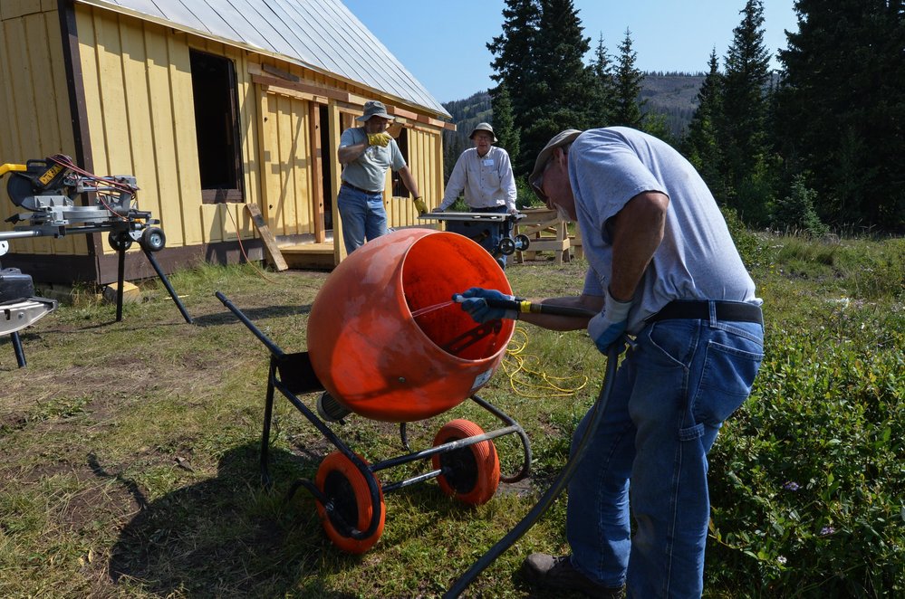 2018-08-01 With the fireplace base poured, they are cleaning the mixer.jpg
