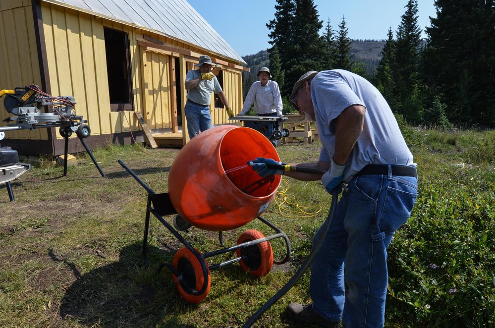 2018-08-01 With the fireplace base poured, they are cleaning the mixer.jpg