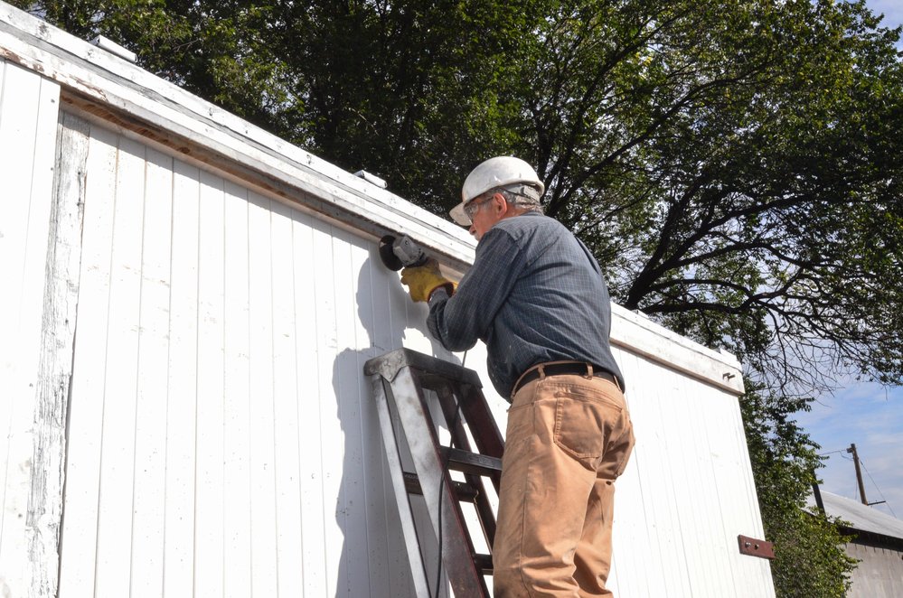 2018-08-03 The work continues on the paint car as one of the team grinds on the upper door guide.jpg