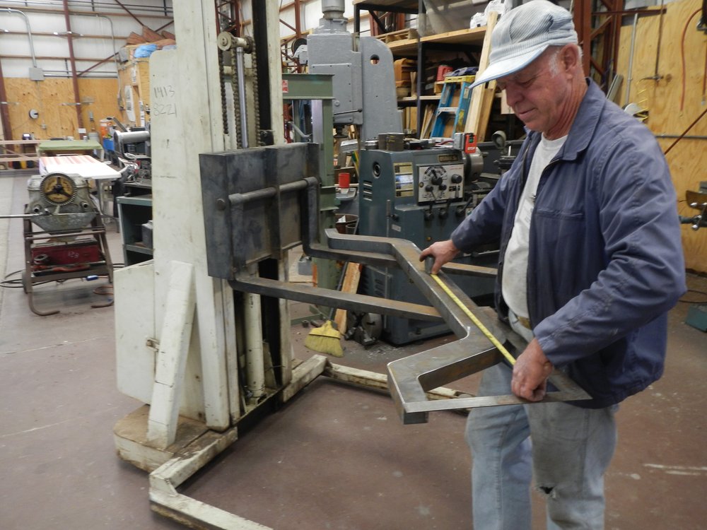 Thursday 2 - A new use for the Pallet Jack - Grant Ball is using it as a portable adjustable height layout table!  Thank you John Cole!  That is a 470 truck part Grant is working on..jpg
