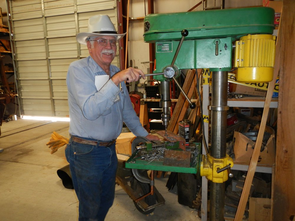 Chuck Deuker drilling angle iron brackets which when are bolted to the Car shelter poles with hold the horizontal girts for the sidewall..jpg