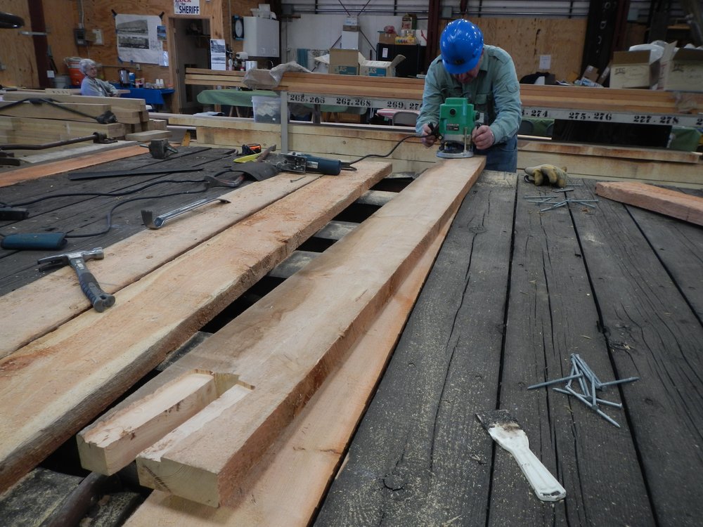 0 - Sam Hauck is doing some fancy Router work to allow some of the decking boards to fit over sill hardware.  The flooring is being put down with ring shank nails..jpg