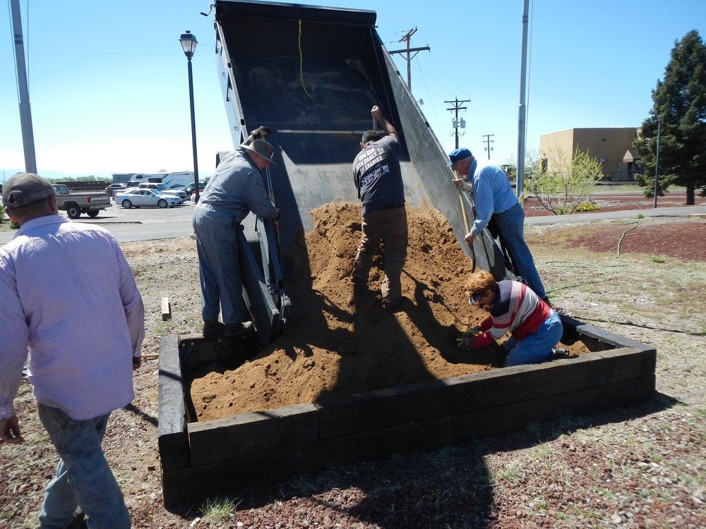 Naomi and jim Sublette filling their new flower bed with quality soil delivered by an Alamosa Nursery..jpg