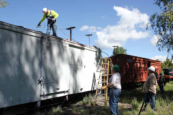 6.19.19 Crew member on the roof spraying it RGW red as support on the ground (1 of 1).jpg