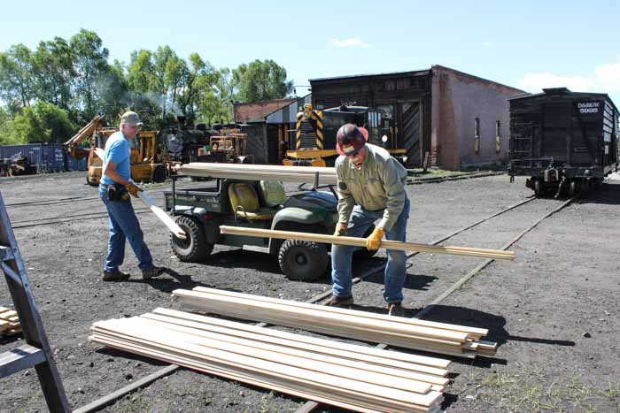 6.19.19 Two members of the team stack up lumber to be used in the conversion (1 of 1).jpg