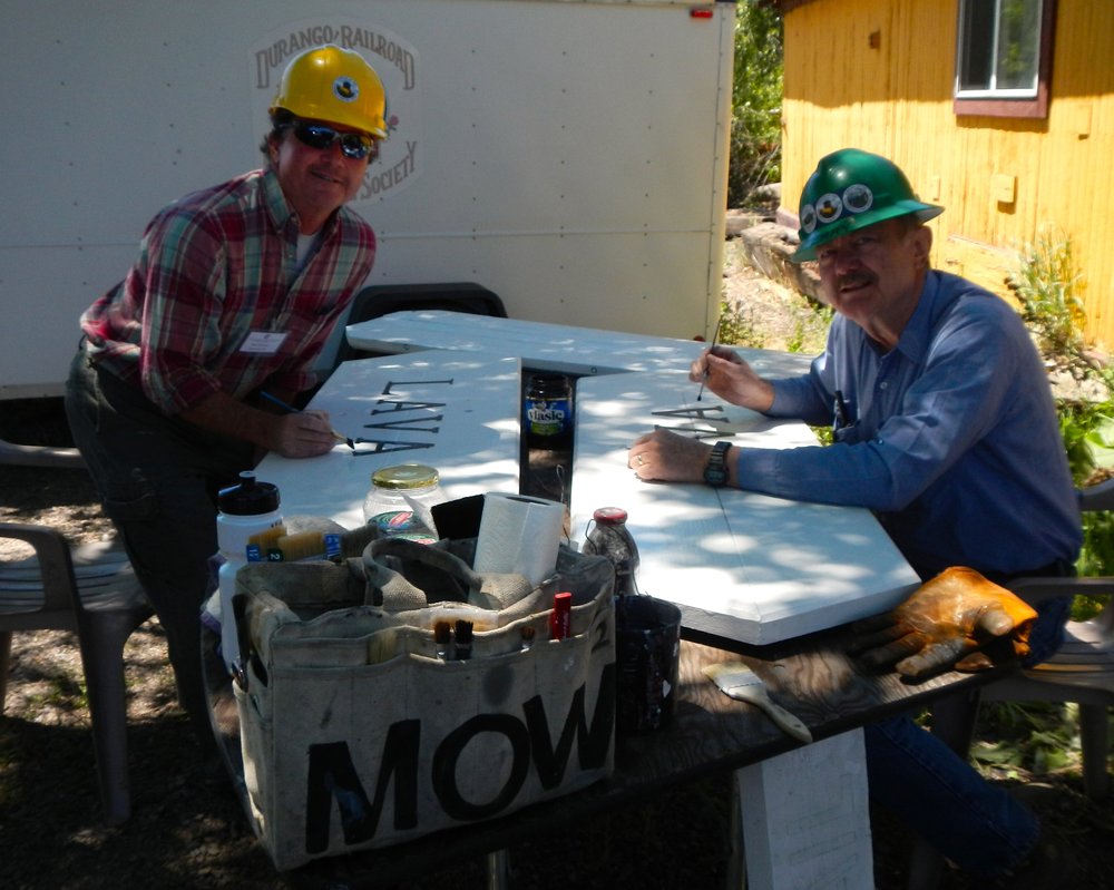 Mow crew of Terry Woolsey and Mike Mahoney  have found a shady place to work on Signs behind the Night watchman's house..jpg