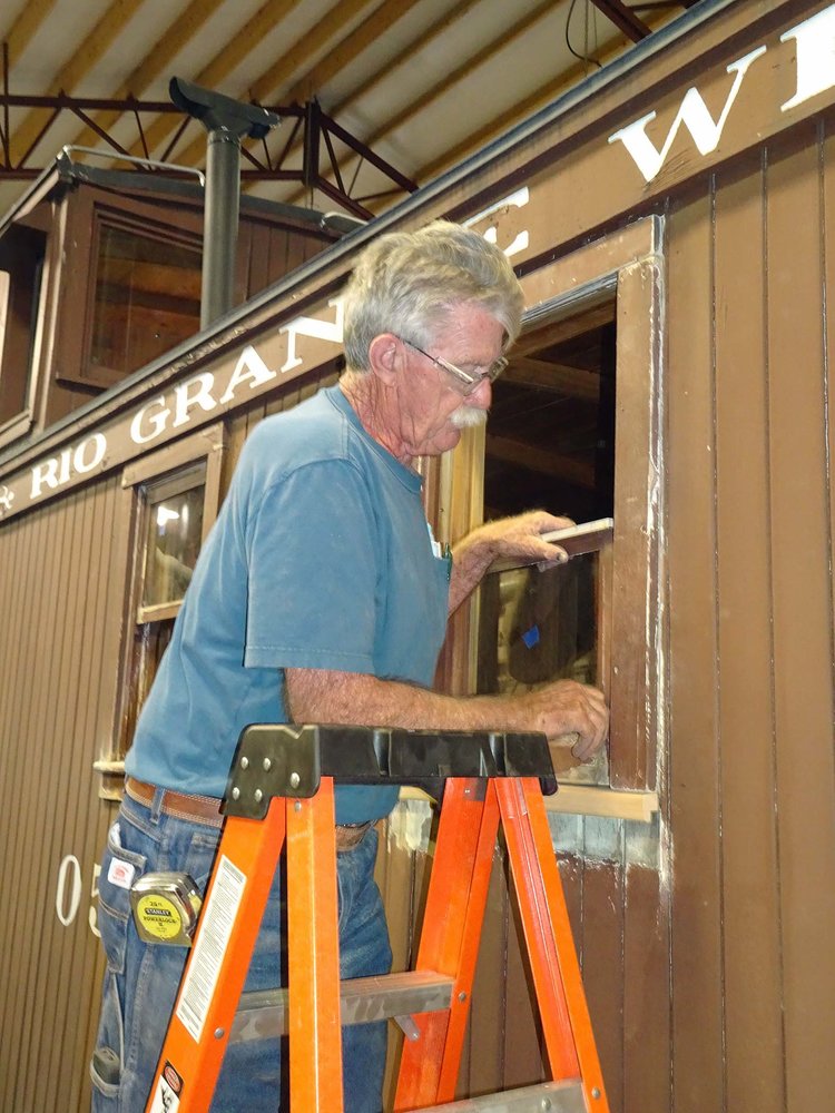 Doc McMillin is working on the window of the second caboose.jpg
