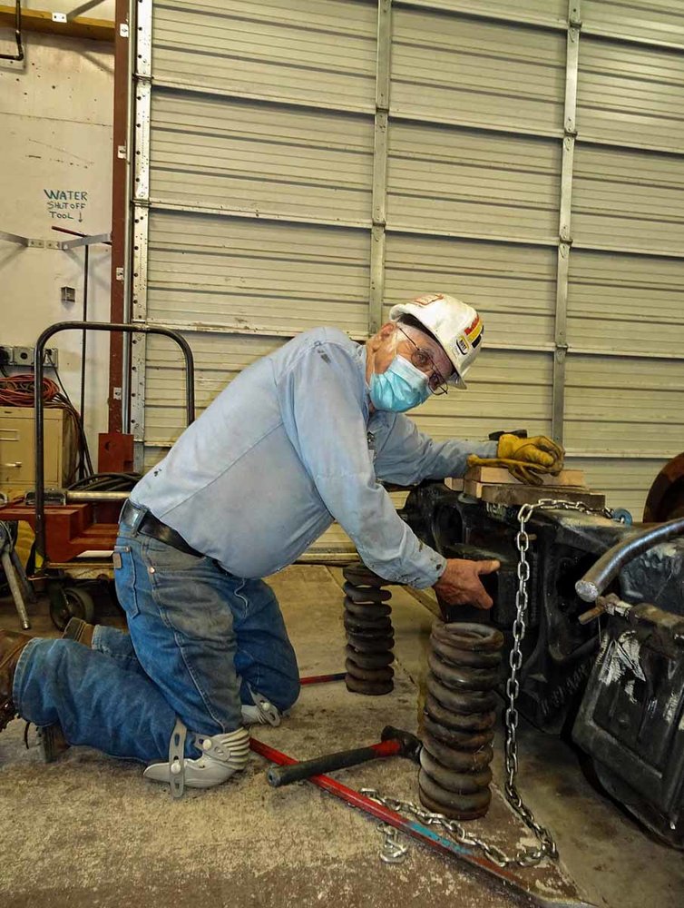 Working on one of the rebuilt trucks with its springs sitting by (1 of 1).jpg